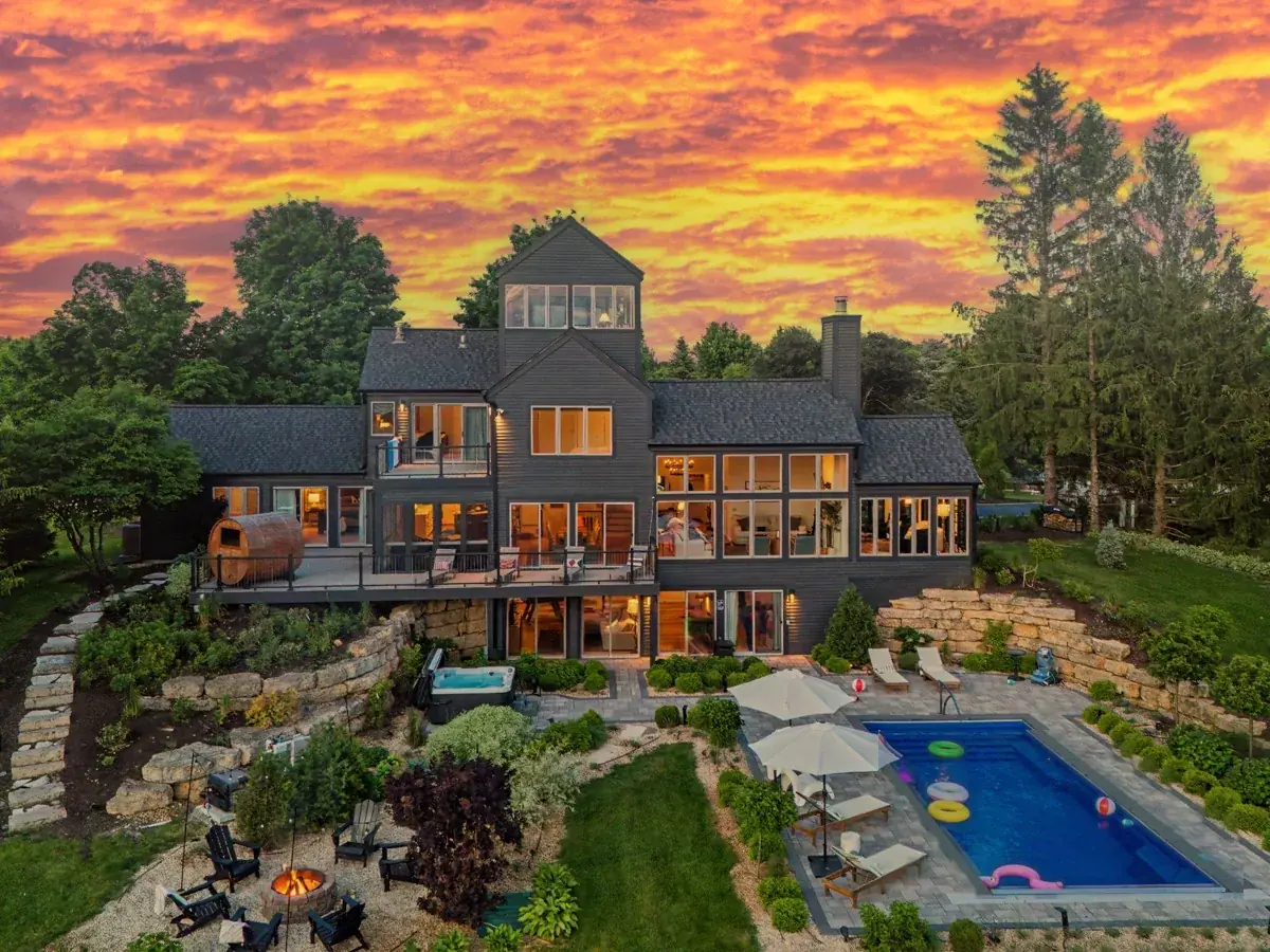 The full backyard at sunset: pool, hot tub, fire pit and sauna