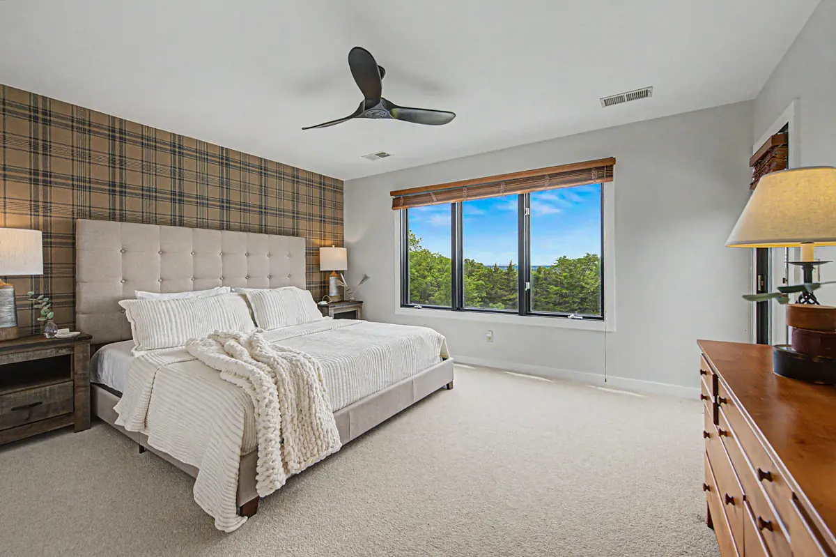 Second-floor king bedroom with tufted headboard